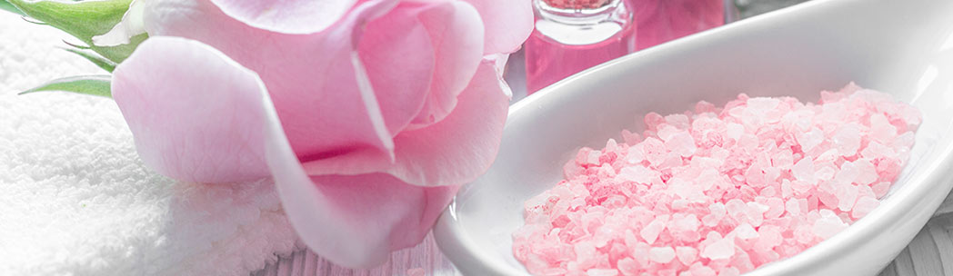 Pink Rose Next to a Bowl of CBD Bath Salts Ready to Be Used